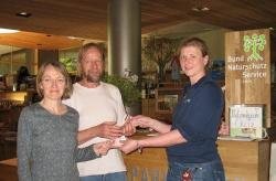 Alexandra Schrötter (rechts) vom Nationalparkladen überreicht Horst Rösing und Rosemarie Wagenstaller vom Bund Naturschutz einen Scheck.